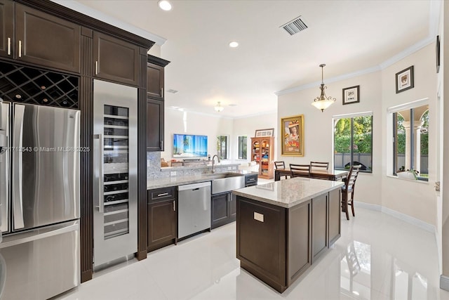 kitchen with dark brown cabinetry, a center island, pendant lighting, and stainless steel appliances