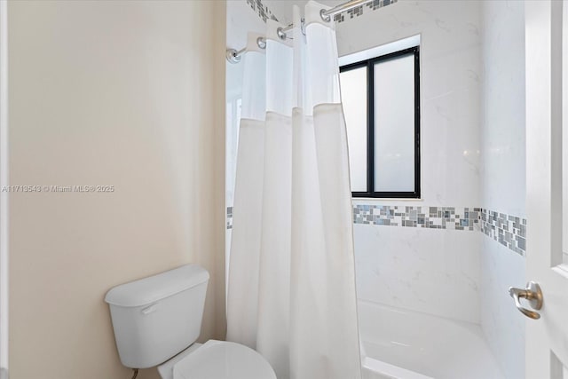 bathroom featuring toilet and shower / bath combo with shower curtain