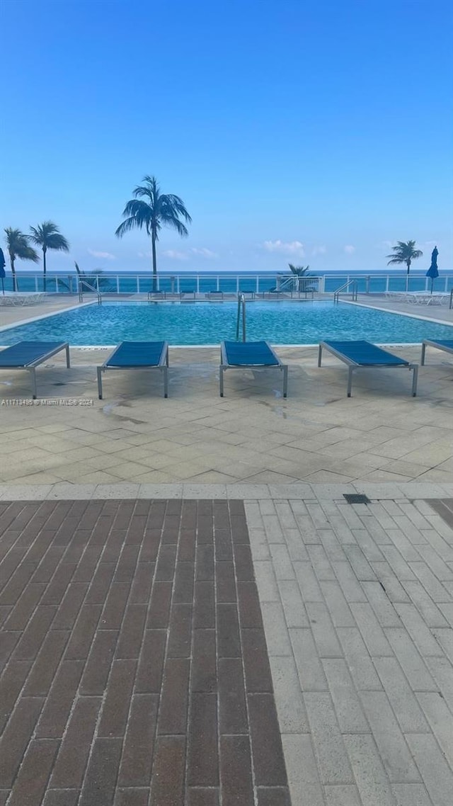 view of swimming pool with a water view