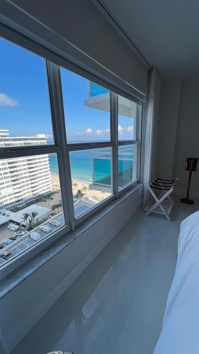 unfurnished bedroom featuring a water view and a view of the beach