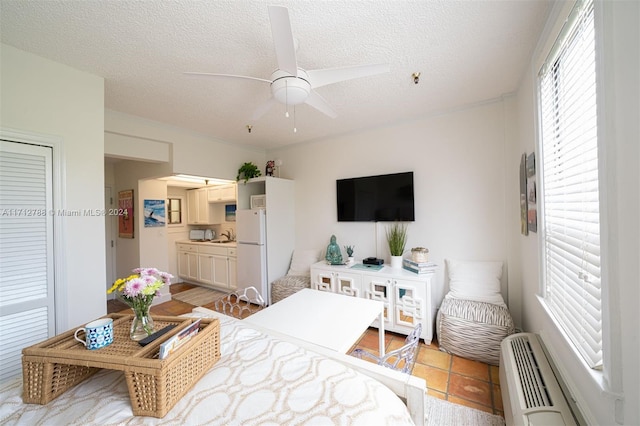 bedroom featuring sink, ceiling fan, light tile patterned floors, a textured ceiling, and a wall mounted AC