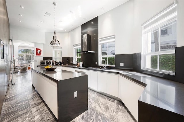 kitchen with white cabinets, sink, decorative backsplash, decorative light fixtures, and a kitchen island