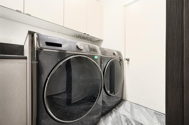 washroom featuring cabinets and washing machine and dryer