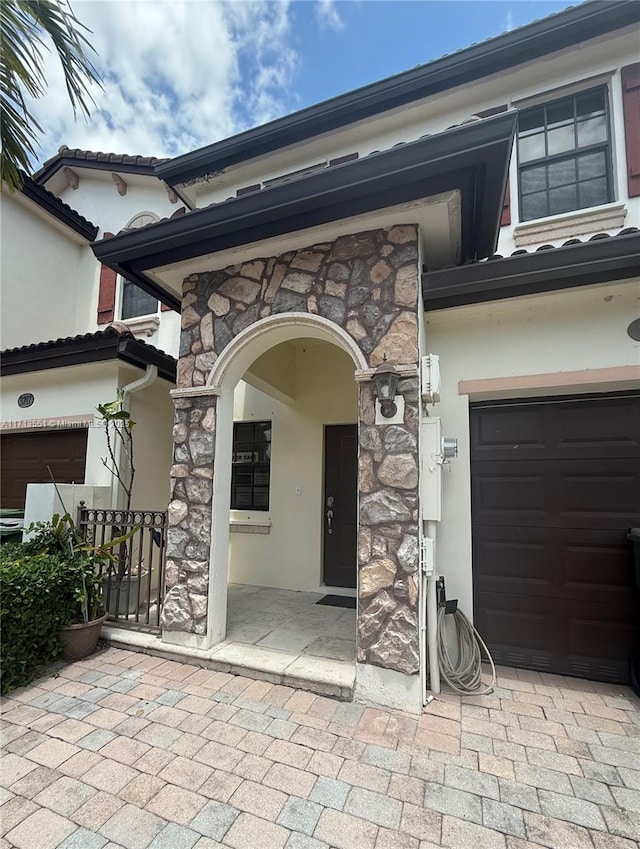 doorway to property with stucco siding and stone siding
