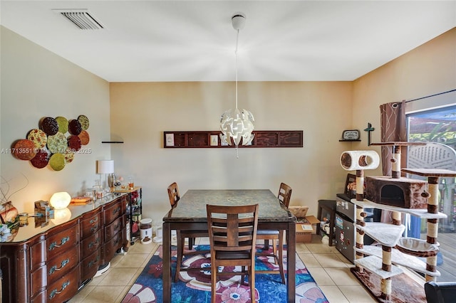 dining room featuring light tile patterned floors, visible vents, and an inviting chandelier