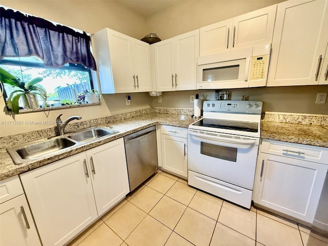 kitchen with white appliances, a sink, and white cabinetry