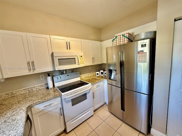 kitchen featuring light stone counters, white appliances, and white cabinetry