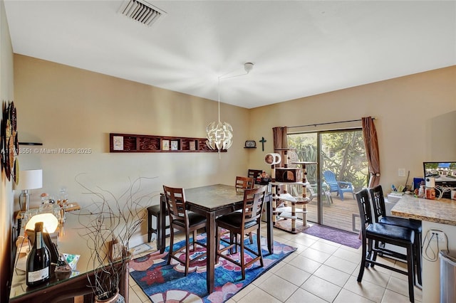 dining room featuring light tile patterned floors, visible vents, and a chandelier