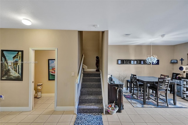 stairway featuring tile patterned flooring, visible vents, and baseboards