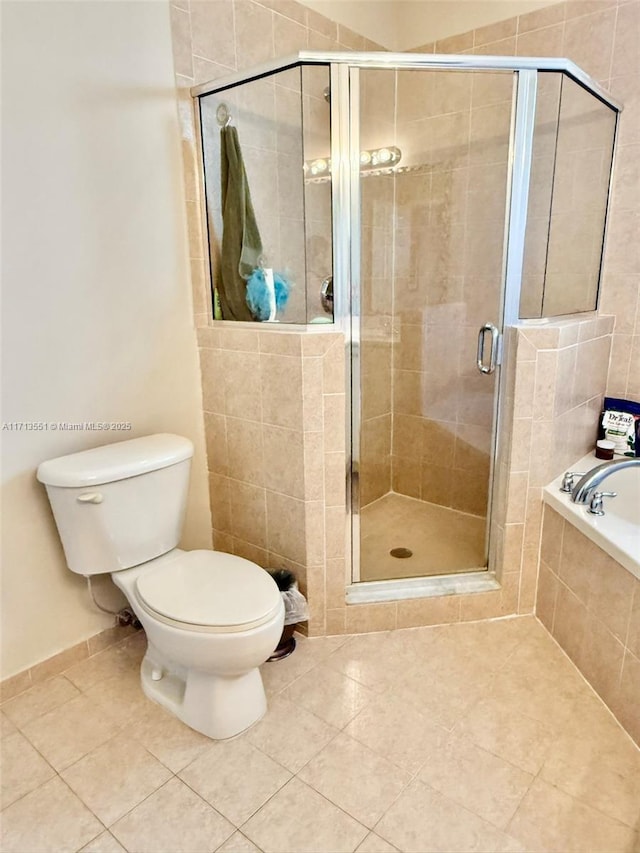 full bath featuring toilet, a shower stall, a bath, and tile patterned floors