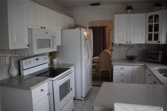 kitchen featuring backsplash, white appliances, crown molding, light tile patterned floors, and white cabinetry