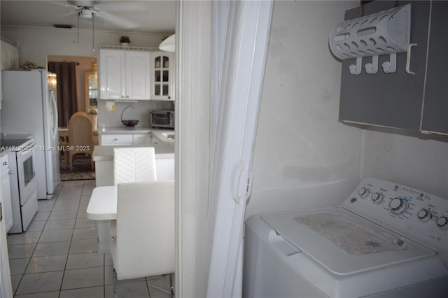 clothes washing area with ceiling fan, light tile patterned flooring, washer / dryer, and crown molding