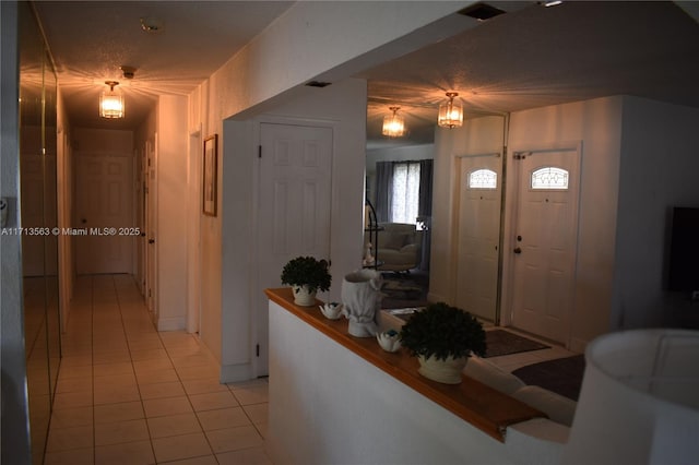 tiled entrance foyer featuring a textured ceiling