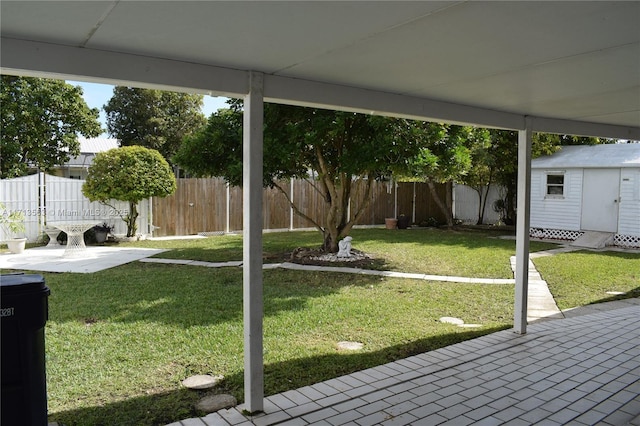 view of yard featuring a storage unit and a patio area