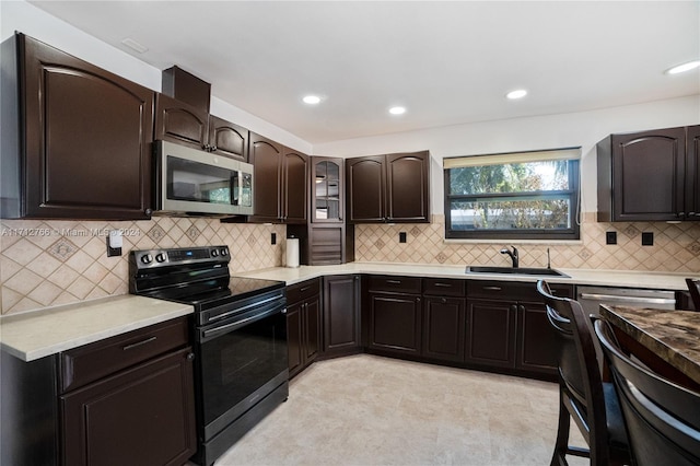 kitchen featuring black range with electric stovetop, dark brown cabinetry, sink, and decorative backsplash