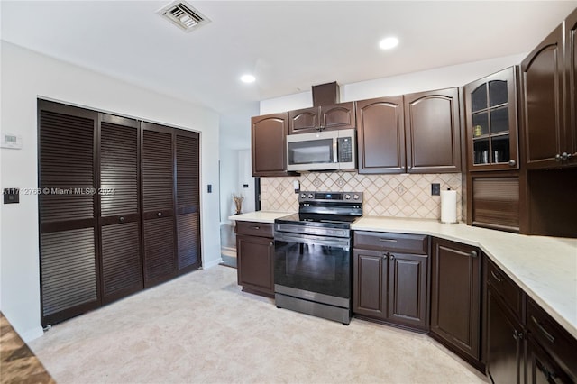 kitchen featuring dark brown cabinetry, decorative backsplash, and appliances with stainless steel finishes