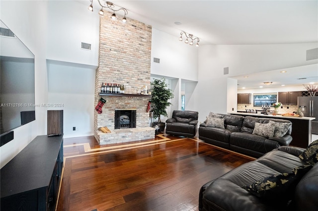 living room featuring a fireplace, dark hardwood / wood-style flooring, and high vaulted ceiling