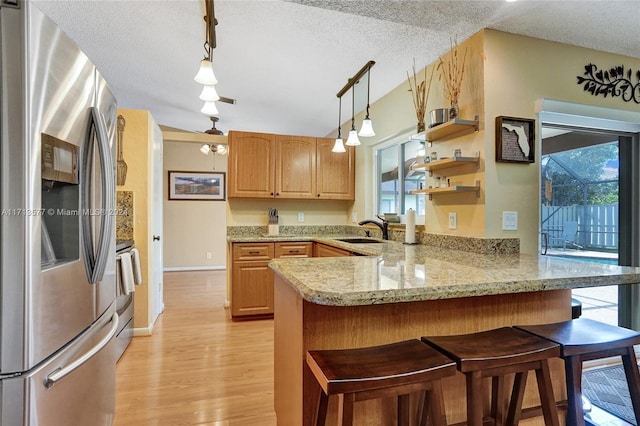 kitchen featuring decorative light fixtures, sink, kitchen peninsula, and stainless steel appliances