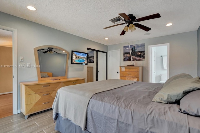 bedroom with ceiling fan, a textured ceiling, and connected bathroom