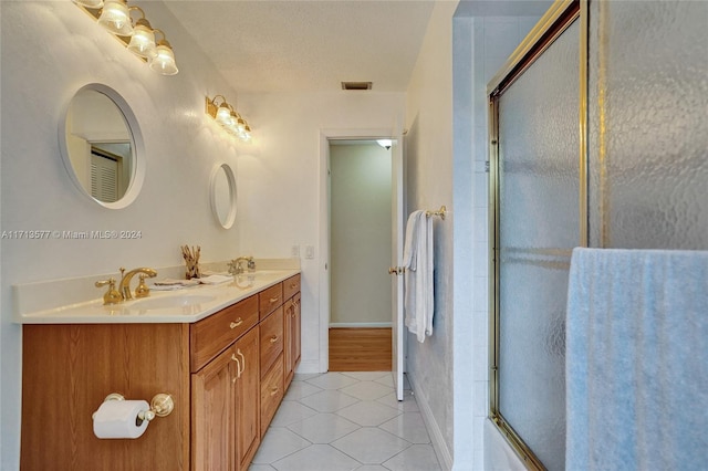 bathroom with tile patterned flooring, vanity, enclosed tub / shower combo, and a textured ceiling