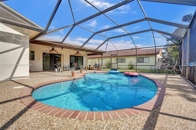 view of swimming pool featuring a lanai, ceiling fan, and a patio area