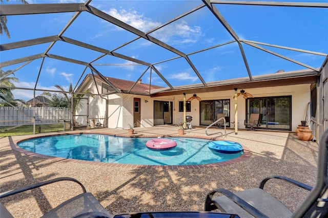 view of pool featuring ceiling fan, a patio, and glass enclosure