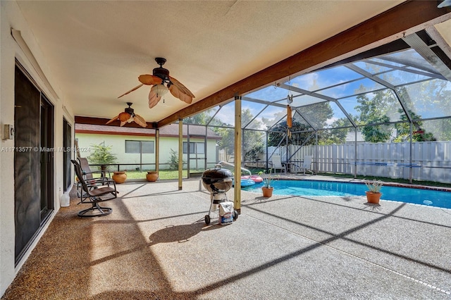 view of swimming pool featuring ceiling fan, a patio area, and a lanai