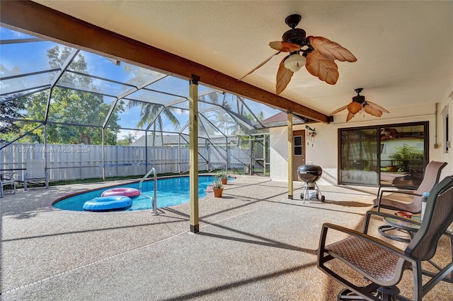 view of swimming pool featuring a patio, glass enclosure, and ceiling fan