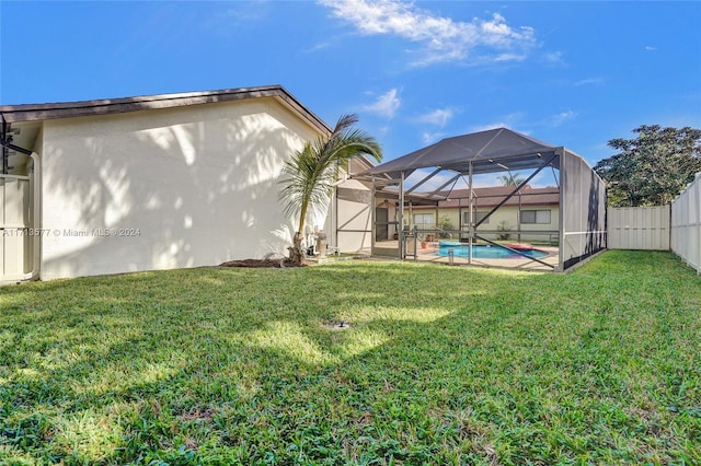 view of yard featuring a fenced in pool and glass enclosure