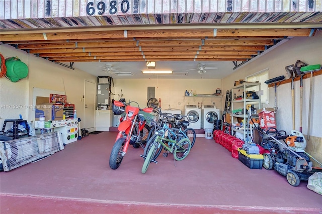 garage featuring washing machine and dryer, electric panel, heating unit, and ceiling fan