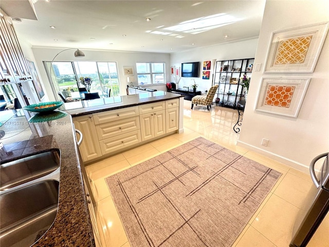 kitchen with sink, light tile patterned floors, and ornamental molding