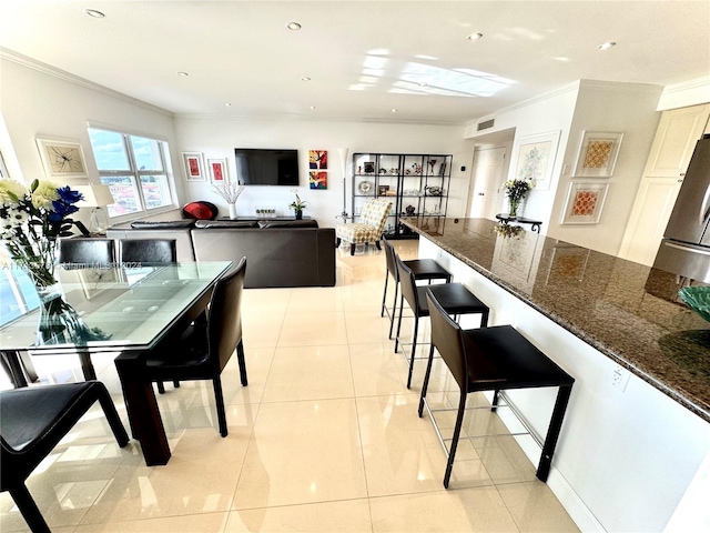 dining space with crown molding and light tile patterned flooring