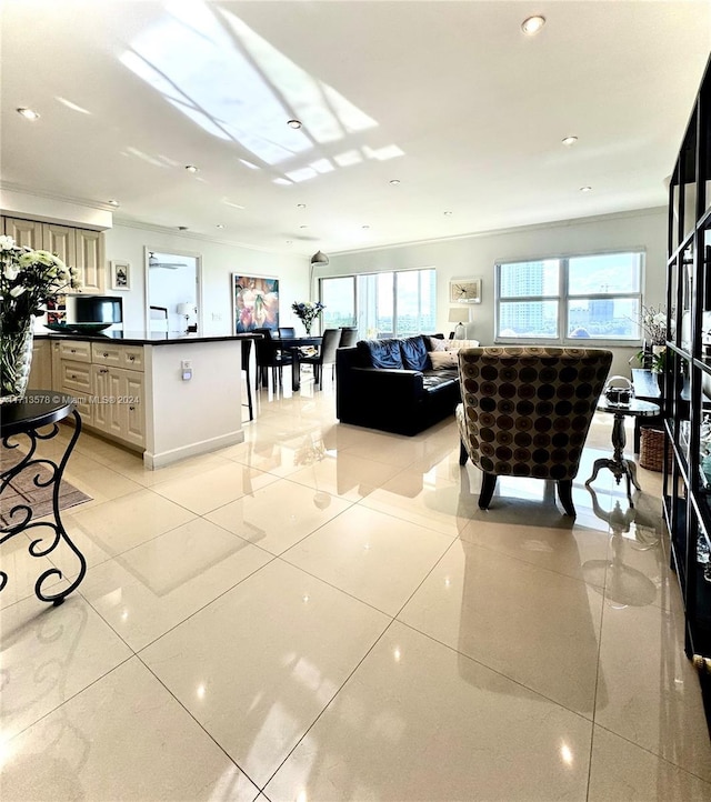 kitchen with cream cabinets, a center island, and light tile patterned flooring