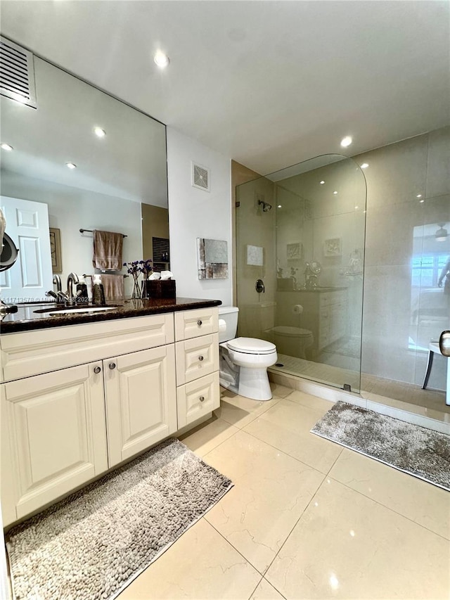 bathroom with vanity, toilet, and a shower with shower door