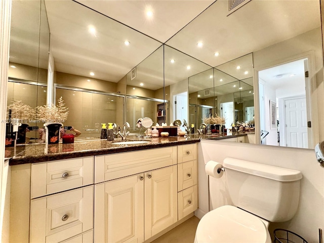 bathroom with vanity, toilet, and an enclosed shower