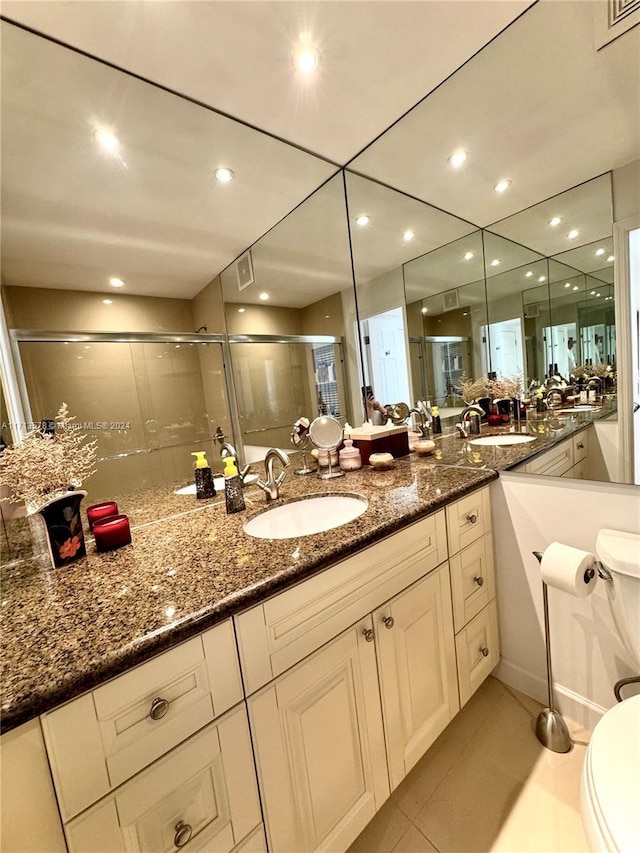 bathroom with toilet, vanity, tile patterned floors, and walk in shower