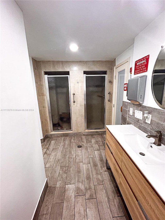 bathroom featuring decorative backsplash, vanity, and walk in shower