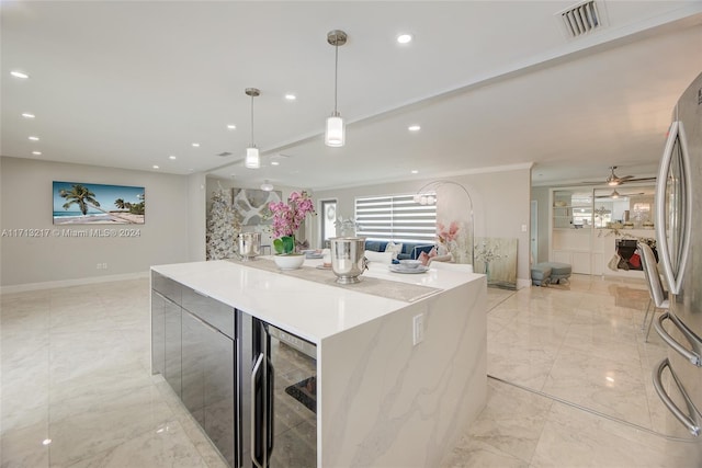 kitchen with ceiling fan, beverage cooler, stainless steel fridge, pendant lighting, and a kitchen island