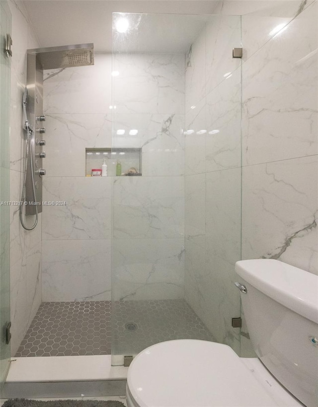 bathroom featuring toilet and a tile shower