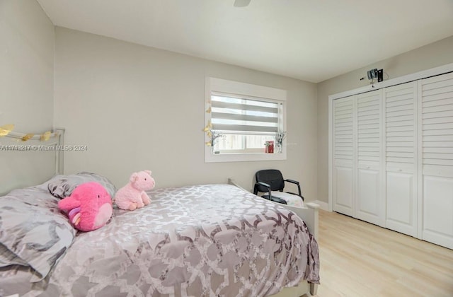 bedroom with light hardwood / wood-style floors and a closet