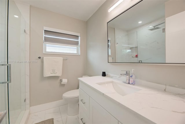 bathroom featuring a shower with door, vanity, and toilet