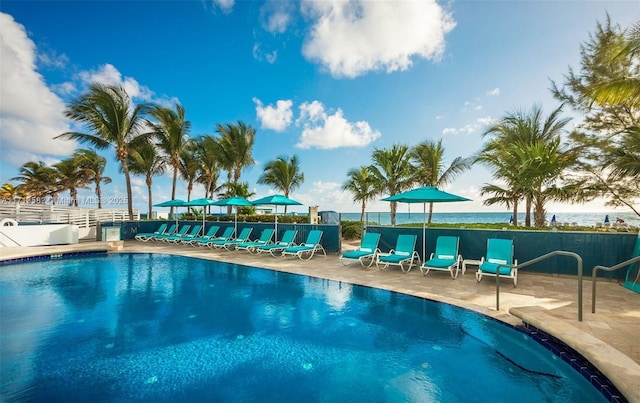 view of pool featuring a water view and a patio area