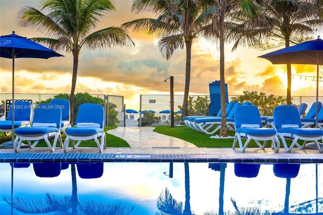 pool at dusk with a patio