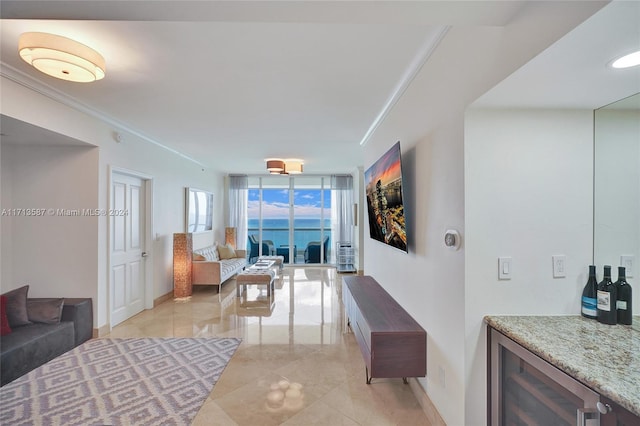 living room with crown molding, light tile patterned floors, indoor bar, and wine cooler