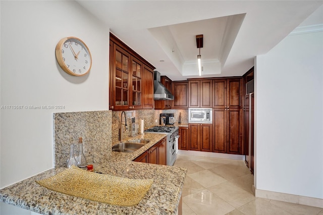 kitchen featuring wall chimney range hood, stainless steel appliances, sink, kitchen peninsula, and a raised ceiling