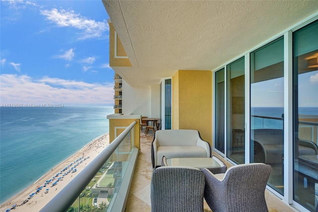 balcony with a water view and a beach view