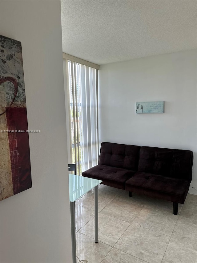 living room with a textured ceiling and a wall of windows