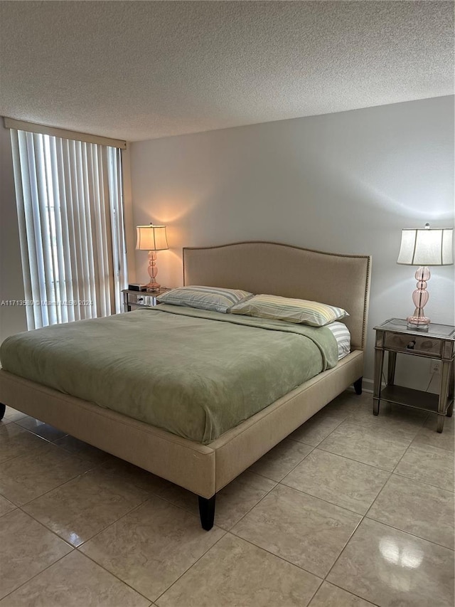 bedroom with light tile patterned flooring and a textured ceiling