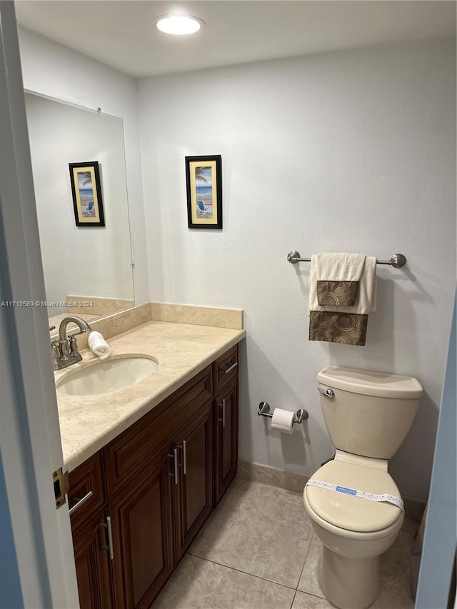 bathroom with tile patterned flooring, vanity, and toilet