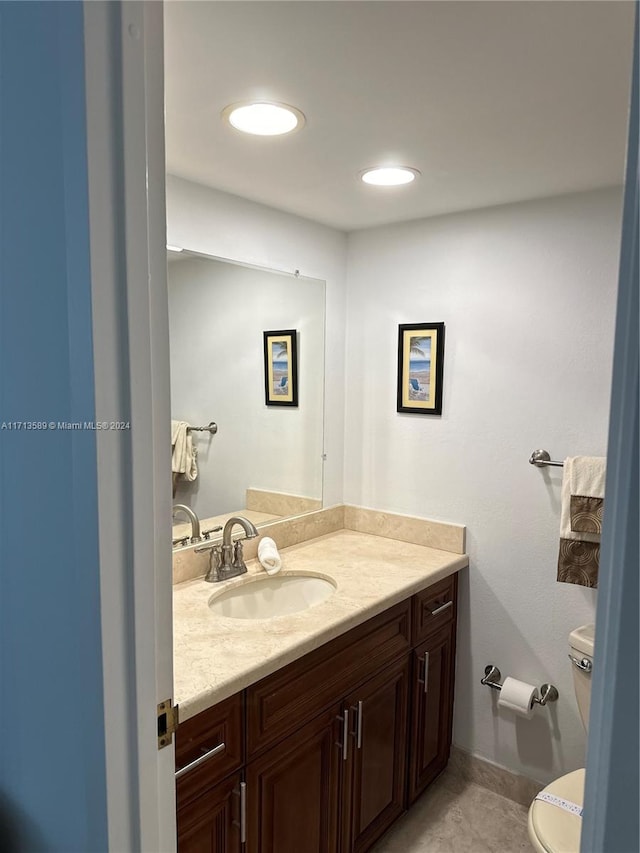 bathroom with tile patterned flooring, vanity, and toilet